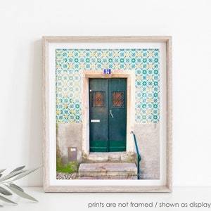 May include: A green door with a blue number "14" above it. The door is surrounded by a wall covered in colorful patterned tiles.