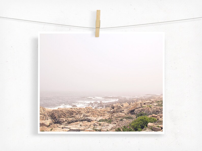 May include: A misty seascape with a rocky coastline and ocean waves crashing against the shore.