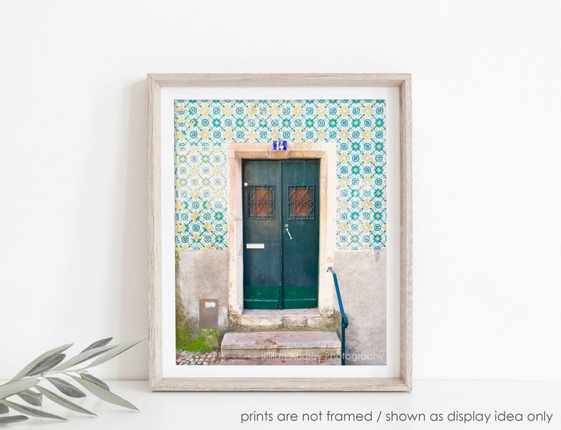 May include: A green door with a blue number "14" above it. The door is surrounded by a wall covered in colorful patterned tiles.