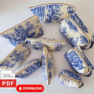 Può includere: Una collezione di trousse di varie dimensioni, con un design pastorale blu e bianco. Le trousse hanno una texture trapuntata, cerniere color oro e uno sfondo color crema. Le trousse sono disposte su una superficie bianca.