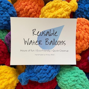 May include: A collection of colorful, reusable water balloons in shades of blue, orange, yellow, green, red, and purple. A white card displays the text "Reusable Water Balloons" with the tagline "Hours of fun / Eco-Friendly / Quick Cleanup."