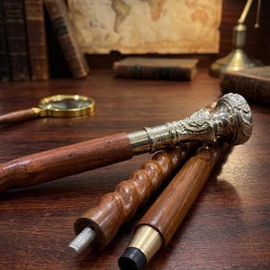 May include: A walking stick featuring a polished silver-toned metal handle with intricate embossed detailing, connected to a dark brown wooden shaft. The shaft is composed of three detachable segments, including one with a spiral-carved texture.
