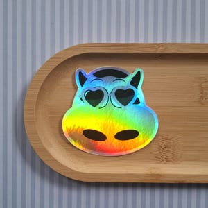 Holografische Koe Sticker met Hartjesbril – Schattige Cartoon Koe Hoofd Decal – Glanzende Boerderij Dierensticker – Kawaii Cow Aesthetic