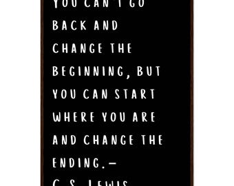 May include: A framed black sign with white text. The text reads: "YOU CAN'T GO BACK AND CHANGE THE BEGINNING, BUT YOU CAN START WHERE YOU ARE AND CHANGE THE ENDING. - C.S. LEWIS."