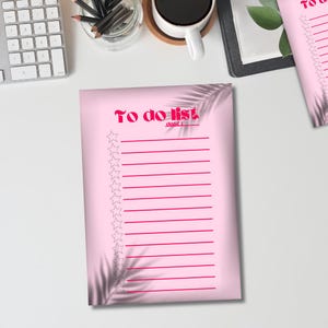 Peut inclure: Liste de choses à faire imprimable rose avec un motif d'ombre de feuille tropicale. La liste comporte 18 lignes avec une étoile au début de chaque ligne. Le texte en haut de la liste dit "To do list".
