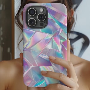 Può includere: Una custodia per telefono con un design olografico iridescente che presenta forme geometriche in tonalità di rosa, blu e viola.
