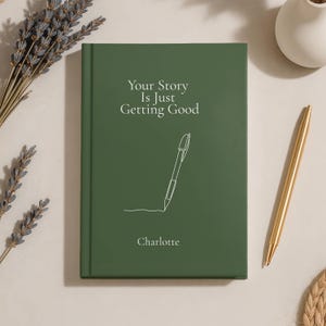 May include: A dark green hardcover journal featuring the white text "Your Story Is Just Getting Good" above a white line-art illustration of a pen and the name "Charlotte" printed in white at the bottom center of the front cover.