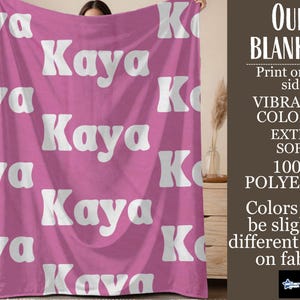 May include: A pink blanket with the name "Kaya" repeated in white, bold, retro-style font. The blanket is made of 100% polyester and is extra soft. The image also includes text that says "Our Blankets" and "Vibrant Colors."