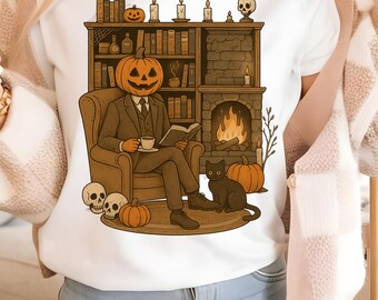 Puede incluir: Camiseta blanca con una ilustración de Halloween. El diseño representa a una persona con cabeza de calabaza leyendo un libro en un ambiente acogedor con chimenea, estanterías, velas y un gato negro. También hay calaveras y calabazas.