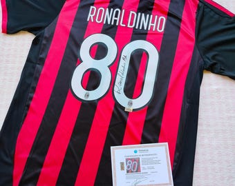 Camiseta del AC Milan firmada por Ronaldinho, número 80, con certificado de autenticidad.