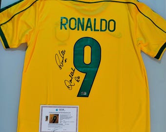 Een T-shirt van Ronaldo Nazario met zijn eigen handtekening en de handtekening van Ronaldinho