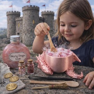 A young girl stirs a steaming pink potion in a metallic pink dragon cauldron with a wooden spoon, alongside a bottle of sleeping dragon elixir and toy accessories outdoors near a castle.