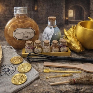 A gold-themed sleeping dragon potion kit including a large elixir bottle, five miniature ingredient jars, a gold dragon cauldron, and accessory tools arranged on a stone surface.