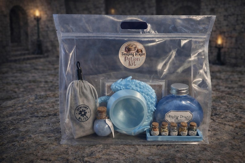 A clear plastic zipper bag containing a light blue sleeping dragon potion kit with a cauldron, bottled elixir, and mini jars sitting on a stone surface.