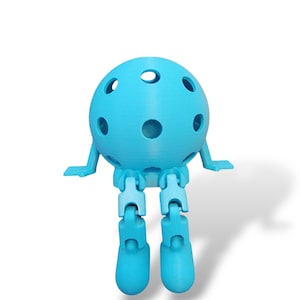 May include: A light blue, 3D-printed articulated ball-shaped figure with a series of holes. The figure has small arms and jointed legs, giving it a playful appearance. The figure is set against a white background.
