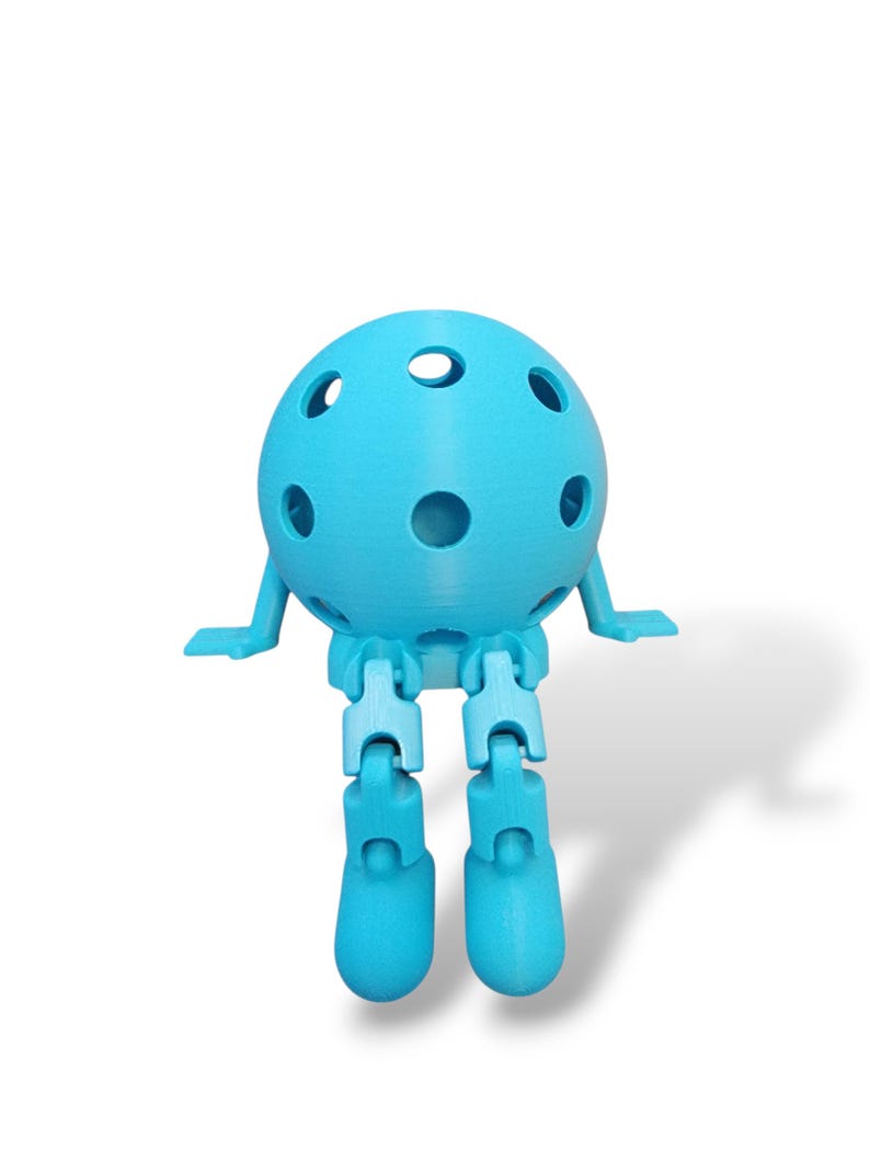 May include: A light blue, 3D-printed articulated ball-shaped figure with a series of holes. The figure has small arms and jointed legs, giving it a playful appearance. The figure is set against a white background.
