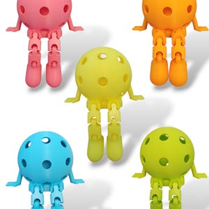 May include: Five colorful, articulated ball-shaped figures with jointed legs and small arms. The figures are in shades of pink, orange, yellow, blue, and green. Each figure has a spherical head with several circular holes.