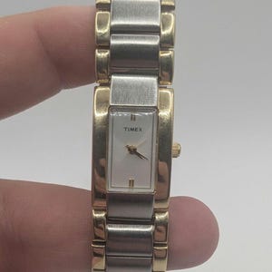 Belle montre débardeur carrée pour femmes Timex, ton argent et or. a encore l'autocollant au dos conviendra aux petits poignets nouvelle batterie. indique l'heure PRÉCISE
