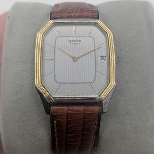vintage 1980's Seiko tank watch. gold and silver tone case with grey face and date function new battery tells accurate time
