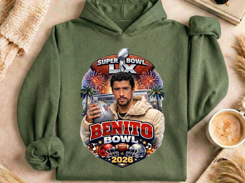 May include: Olive green hoodie featuring a graphic of a man holding a football, with the text "Super Bowl LX" and "Benito Bowl 2026". The design includes football helmets, fireworks, and palm trees.