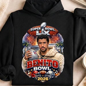 May include: Black hooded sweatshirt featuring a graphic of a man holding a football, with the text "Super Bowl LX" and "Benito Bowl 2026". The design includes fireworks, palm trees, and football helmets.