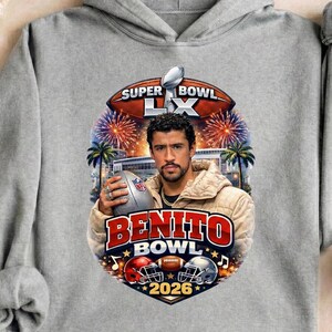 May include: A gray hoodie featuring a graphic with the text "Super Bowl LX" and "Benito Bowl 2026". The graphic includes a football, fireworks, palm trees, and a portrait of a man holding a football.