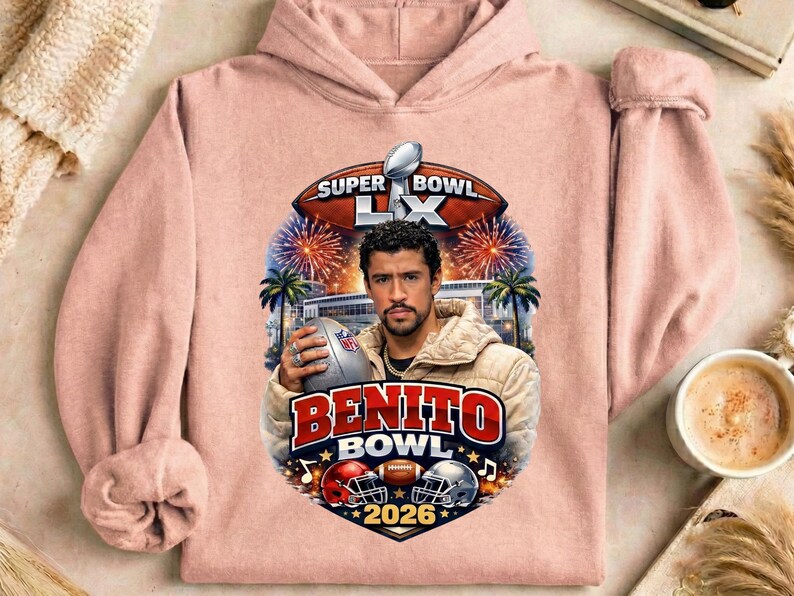 May include: A light pink hoodie featuring a graphic of a man holding a football, with the text "BENITO BOWL 2026". The design includes a football, helmets, fireworks, and palm trees, with "SUPER BOWL LX" at the top.