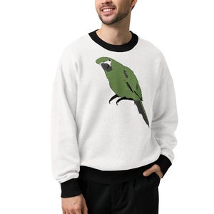 May include: A white long-sleeve sweatshirt featuring a black crew neckline and black sleeve cuffs. The center of the chest displays a graphic illustration of a green parrot with a white face patch and a dark beak, shown in a side profile view.