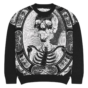 May include: Black crew neck jumper with a detailed grayscale image of a skeleton within an ornate oval frame. The design includes intricate patterns and embellishments, with solid black sleeves and neckline. The jumper's design is centered on the front.