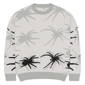 May include: A light gray sweater with a crew neck and ribbed cuffs and hem. The sweater features a repeating pattern of gray and black spiders. The spiders are stylized with textured details, creating a unique design.