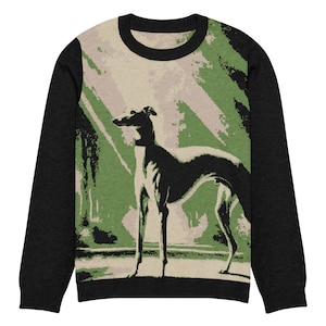 May include: Crew neck sweatshirt with black sleeves and a graphic of a greyhound dog. The dog is in a standing pose against a background of green and beige brushstrokes. The sweatshirt has a black collar.