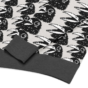 May include: A light gray sweatshirt with a repeating pattern of black crow illustrations. The cuffs and hem are a dark gray ribbed knit. The crows have open beaks and detailed eyes.