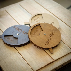 May include: Three wooden office door signs with a circular design. One is gray and says "Closed" and "s' Office". Another is light wood and says "Please knock". The third is brown and says "Come in" and "Laura Pierce".