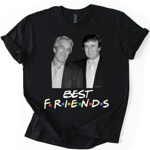 May include: Black t-shirt with a graphic of two men and the text "BEST FRIENDS" in colourful letters. The shirt has rolled-up sleeves and is displayed on a white background.