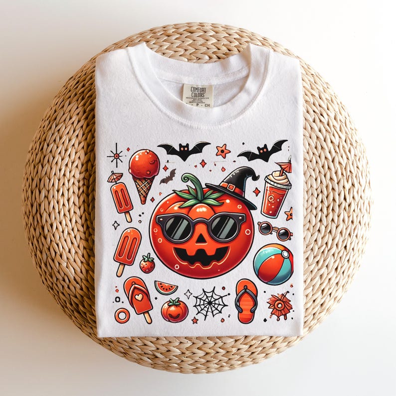 May include: A white t-shirt featuring a central graphic of a jack-o'-lantern tomato wearing sunglasses and a witch hat. Surrounding the tomato are summer and Halloween icons including ice cream, popsicles, a beach ball, flip-flops, and bats.