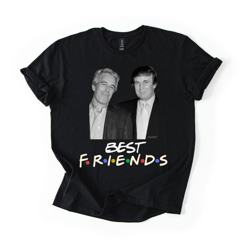 May include: Black t-shirt with a graphic of two men and the text "BEST FRIENDS" in colourful letters. The shirt has rolled-up sleeves and is displayed on a white background.