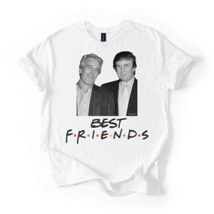 May include: White t-shirt with a black and white image of two men. The text "BEST FRIENDS" is printed in a colourful font below the image. The shirt is made of a soft material.