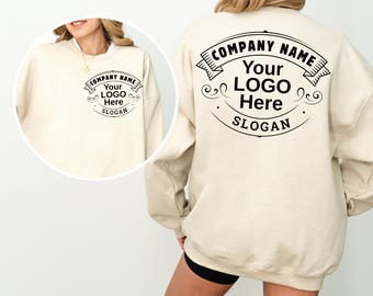May include: Cream-colored sweatshirt with a circular logo design on the front and back. The logo includes the text "COMPANY NAME", "Your LOGO Here", and "SLOGAN" in a black, decorative font. The sweatshirt is a casual style.