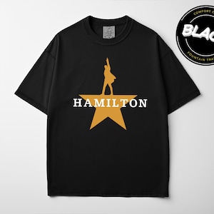 A black t-shirt with a yellow star and the word "HAMILTON" printed on it.