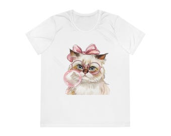 Può includere: T-shirt bianco con un'illustrazione ad acquerello di un gatto con occhiali e fiocco rosa, che soffia una bolla rosa. Il gatto ha il pelo marrone chiaro. La maglietta ha uno scollo tondo.