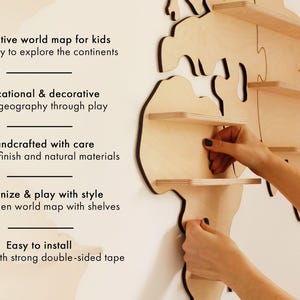 May include: A wooden world map with shelves, designed for children. The map is made of light-coloured wood and features a 3D design. Text on the left side reads: "Interactive world map for kids" and "Educational & decorative". Easy to install.