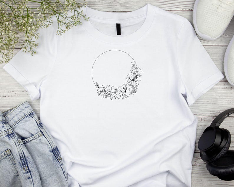 Puede incluir: Camiseta blanca con un contorno negro de un c&iacute;rculo con flores alrededor.