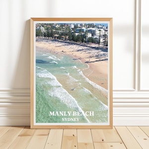 Könnte beinhalten: Eine Luftaufnahme von Manly Beach in Sydney, Australien. Das Foto zeigt den Strand, das Meer und die Stadt im Hintergrund. Der Text "Manly Beach Sydney" ist unten auf dem Bild gedruckt.