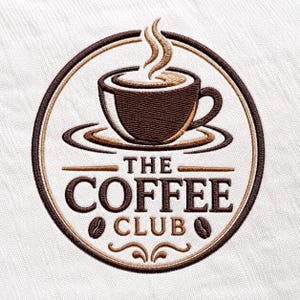 May include: A circular embroidered patch featuring a dark brown coffee cup with steam rising above it. The text THE COFFEE CLUB is centred below the cup, flanked by two coffee beans, all enclosed within a dark brown circular border on white fabric.