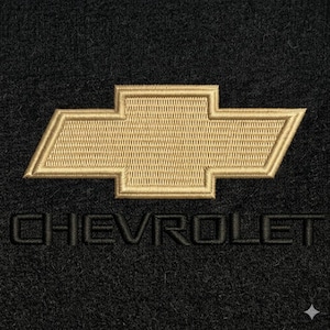 May include: Black car floor mat with a gold embroidered Chevrolet logo. The Chevrolet logo is a gold bow tie design. The word "CHEVROLET" is embroidered in black below the logo.