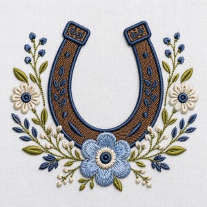 Peut inclure: Un motif de broderie représentant un fer à cheval marron bordé de bleu foncé, centré au-dessus d'une grande fleur bleu clair. Le fer à cheval est flanqué de brins symétriques de feuilles vertes, de petites fleurs blanches et de boutons bleu foncé.