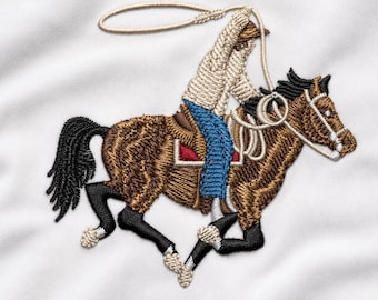 May include: An embroidered patch featuring a brown horse with a black mane and tail, ridden by a figure in a beige top and blue jeans. The rider holds a beige lasso above their head. The horse has white markings on its lower legs and face.