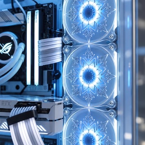 May include: A computer case interior featuring three cooling fans with snowflake-shaped blades illuminated by bright blue LED lights. The system includes white sleeved power cables, a white graphics card with RTX branding, and a motherboard component.