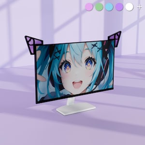 May include: A computer monitor displaying an anime character with blue hair and large eyes. The monitor has black cat ear-shaped decorations. The monitor is white and sits on a white stand. The background is a light purple colour.