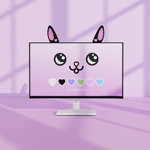 May include: A computer monitor with a cartoon cat face on the screen. The screen displays a pink background with a cat face, black ears, and a selection of heart-shaped color options. The text "+ colours" is below the hearts.